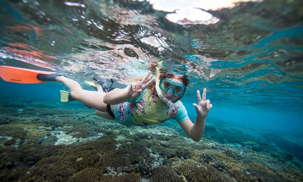 Girl snorkelling over reef Port Douglas