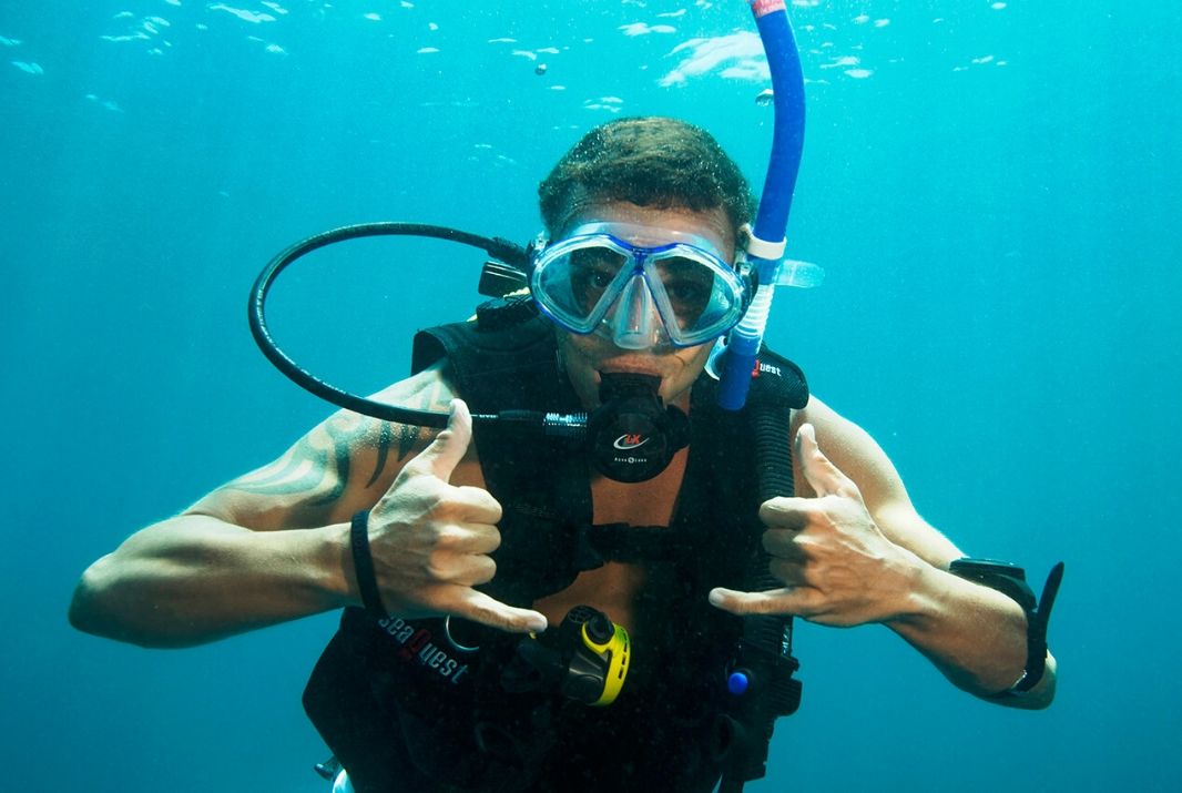Man snorkelling giving shaka to camera