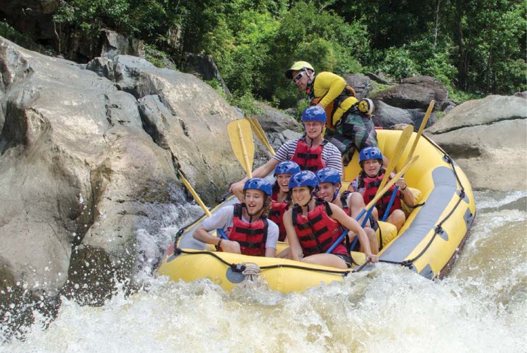 Tour group Smiling going through rapids in Cairns
