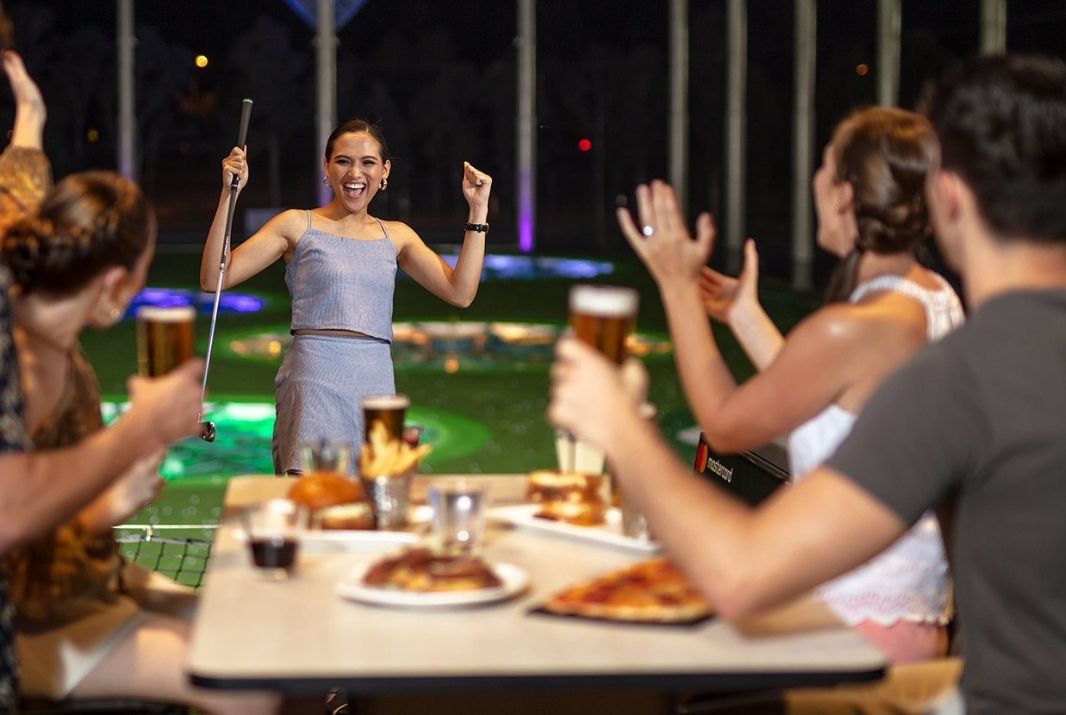 Group of friends cheering at Topgolf Gold Coast