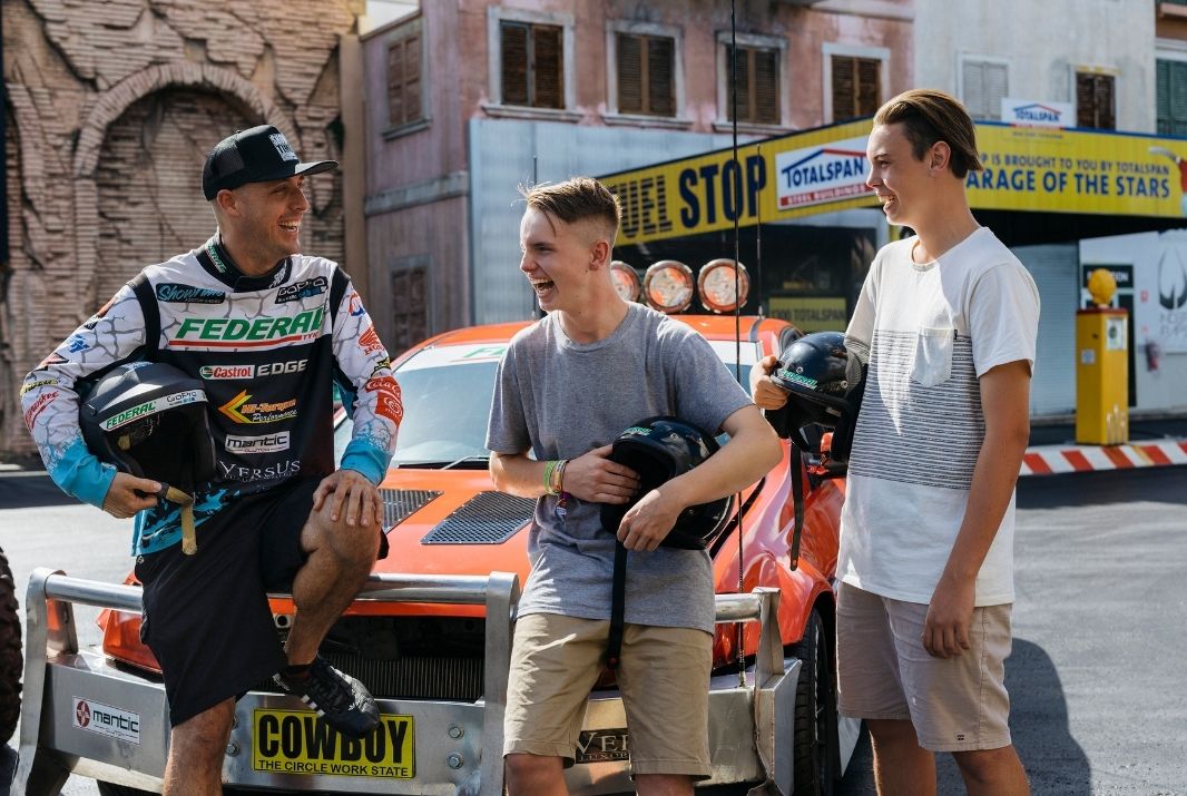 Two guys chatting with Stunt Driver near car Warner Bros. Movie World