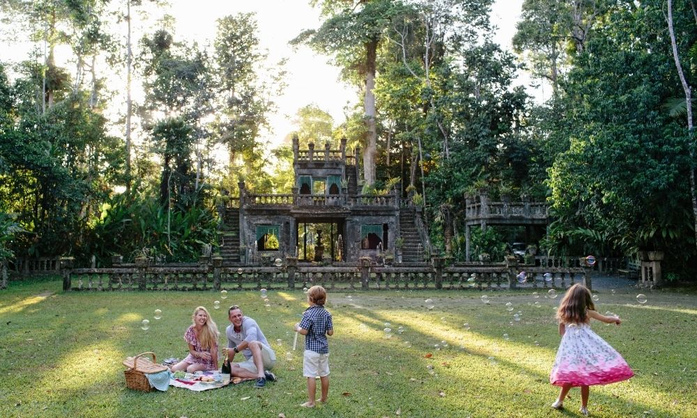 Family have a picnic in front of the castle at Paronella Park