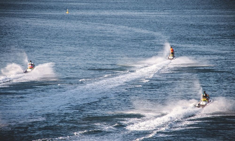 Three people ride their jet skis in The Whitsundays