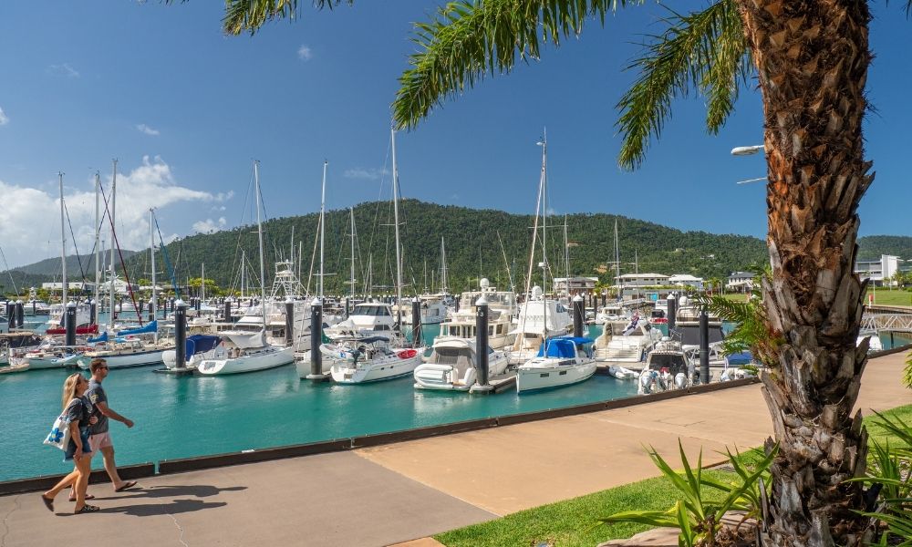 Couple walking through Airlie Beach Marina