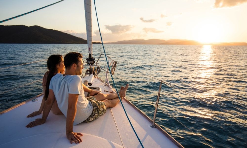 Couple sitting on a sailing cruise looking at the sunset