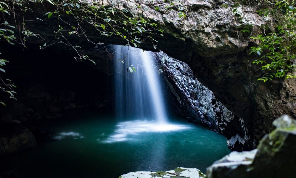 Waterfall flows through a natural bridge in the Gold Coast Hinterland