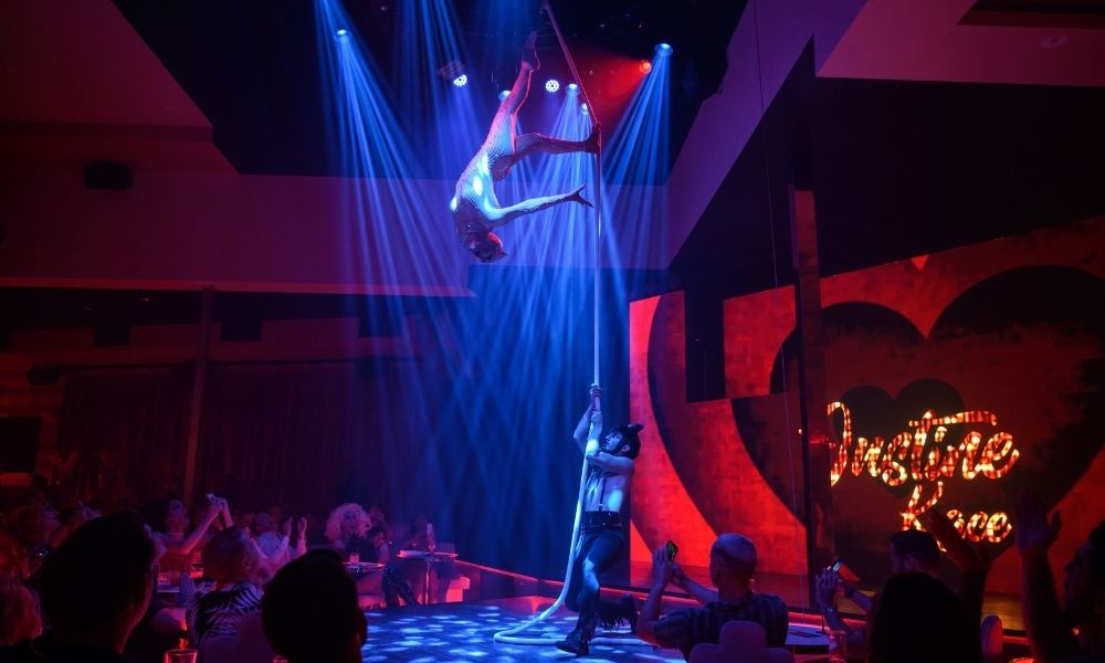 Woman performs acrobatics on silks at Pink Flamingo