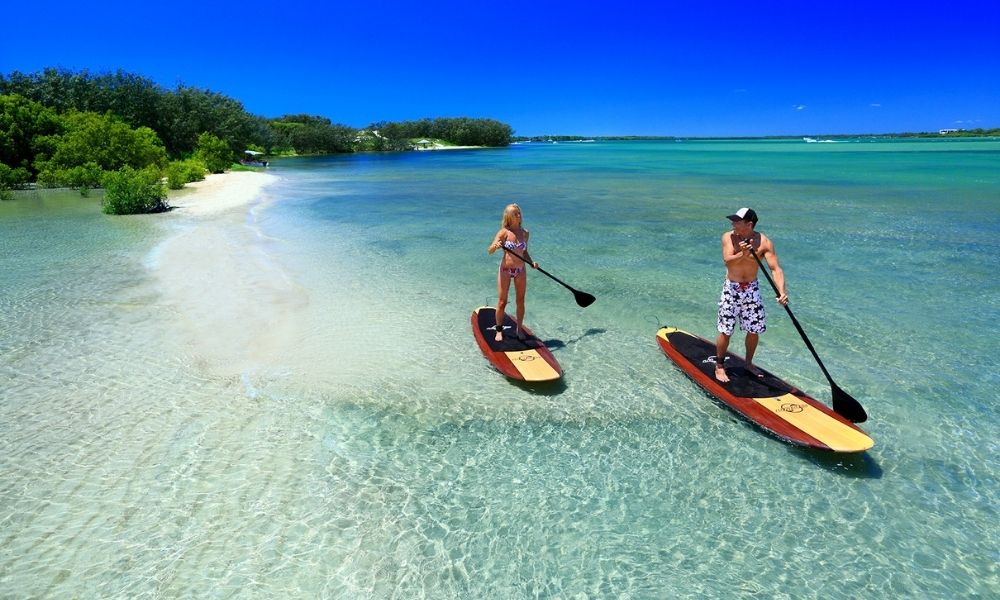 Couple stand up paddle boarding together in the Sunshine Coast