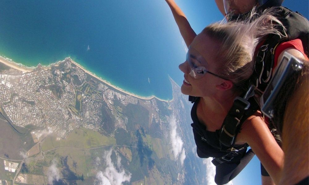 Woman skydives over Noosa Beach