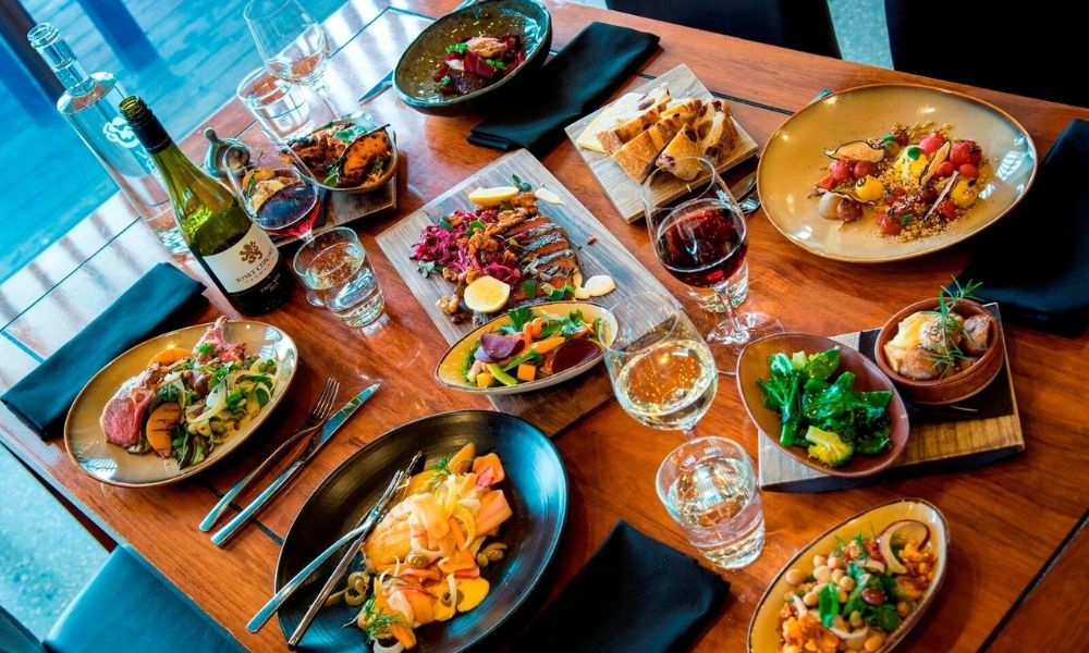 Table full of Josef Chromy Wines and dishes