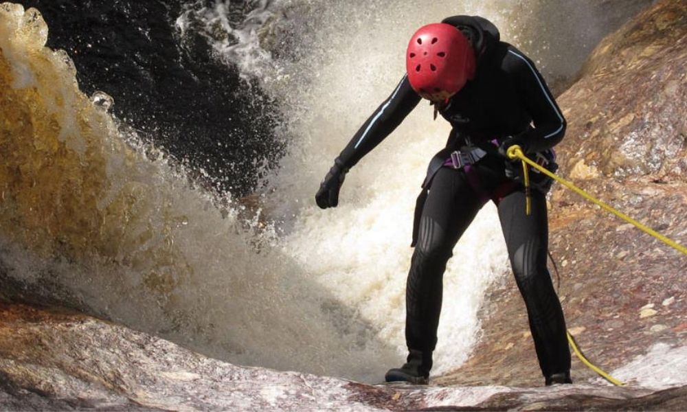 Woman canyoning down waterfall in Launceston