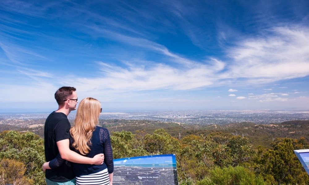 Couple look out over the national park and Adelaide skyline from Mount Lofty Summit