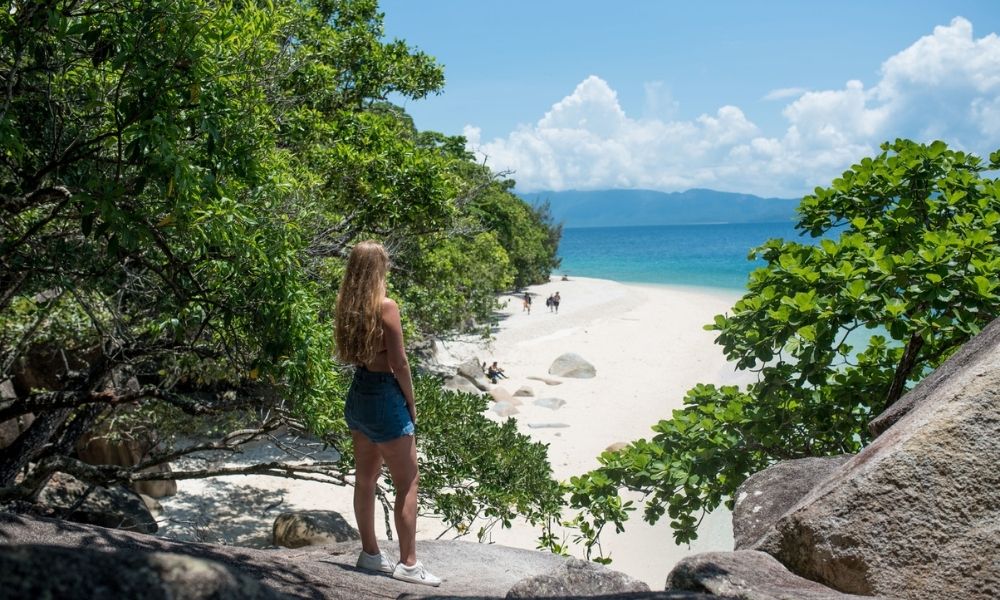 Woman standing on rock onlooking the beach on Fitzroy Island